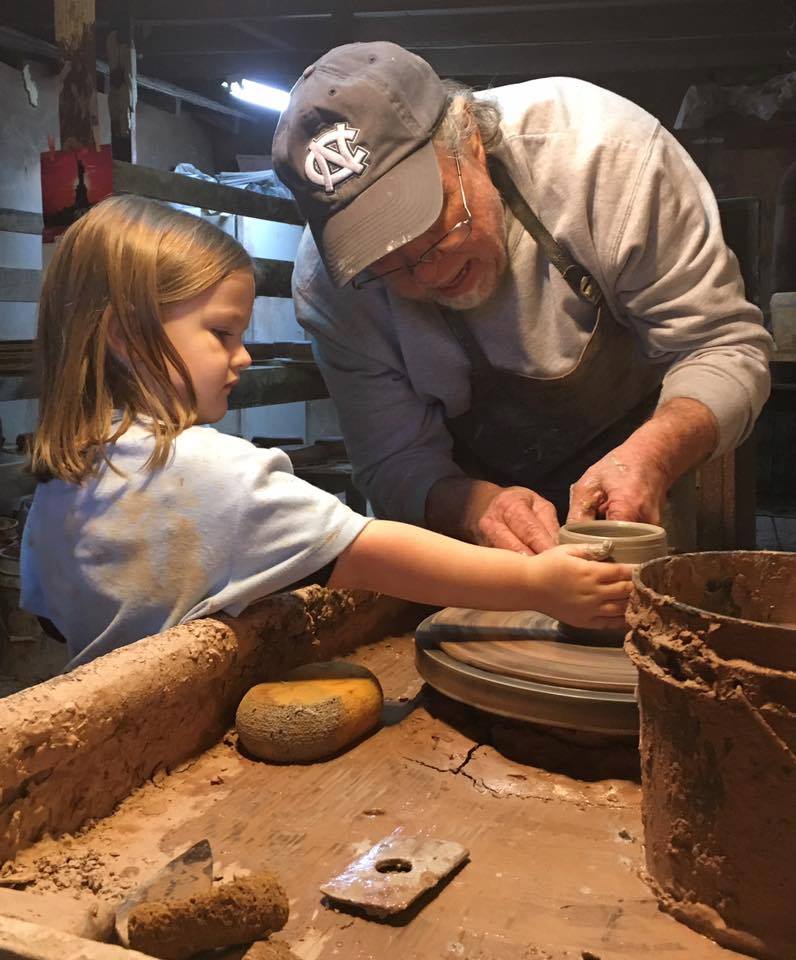 Boyd Owens teaching his granddaughter Clara Jane to throw at the wheel