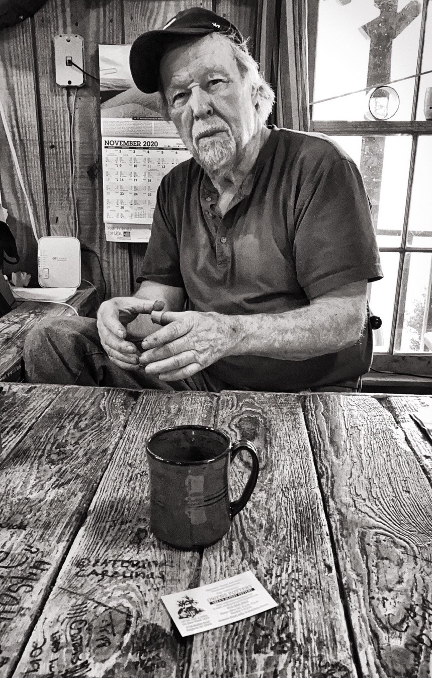 Boyd Owens at the pottery shop table with an Owens mug