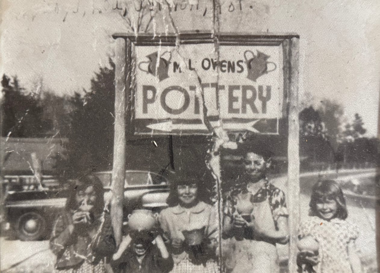 M.L. Owens Pottery sign with children holding pottery